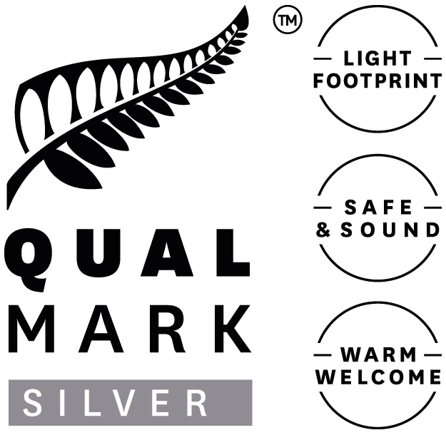 Qualmark Silver logo with fern leaf and three icons: light footprint, safe and sound, warm welcome.